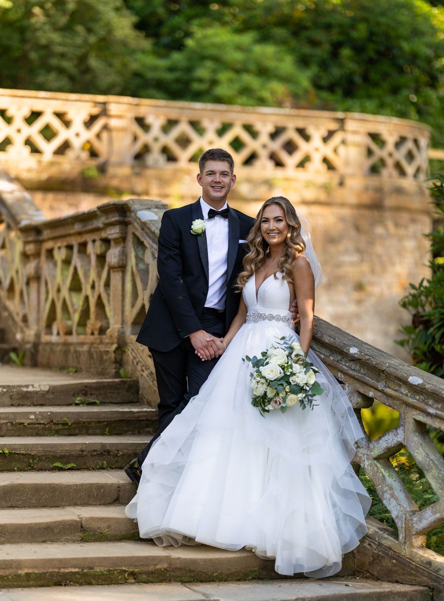 Bride and groom on steps at Hever castle, Kent
