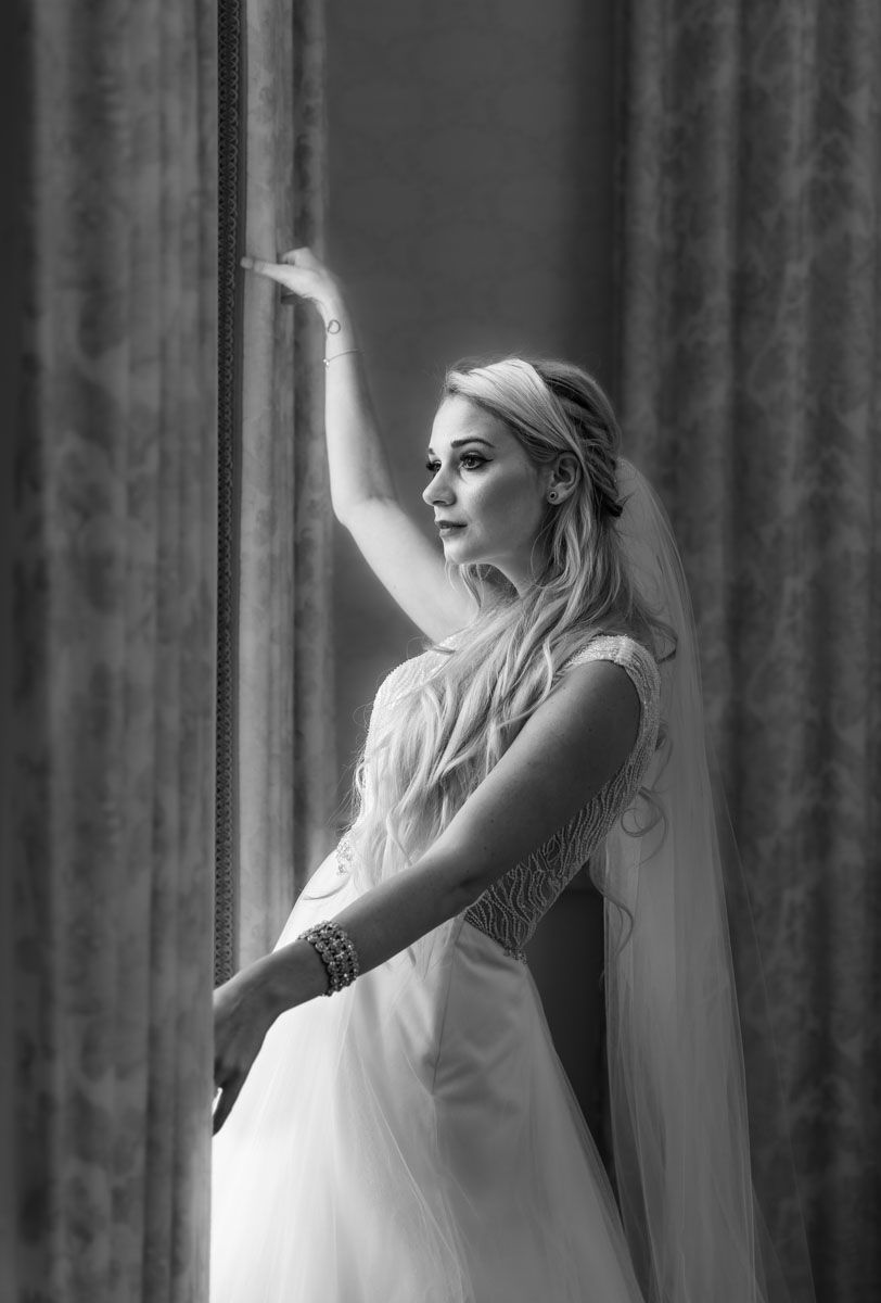 Bride in elegant pose by window in grand country house
