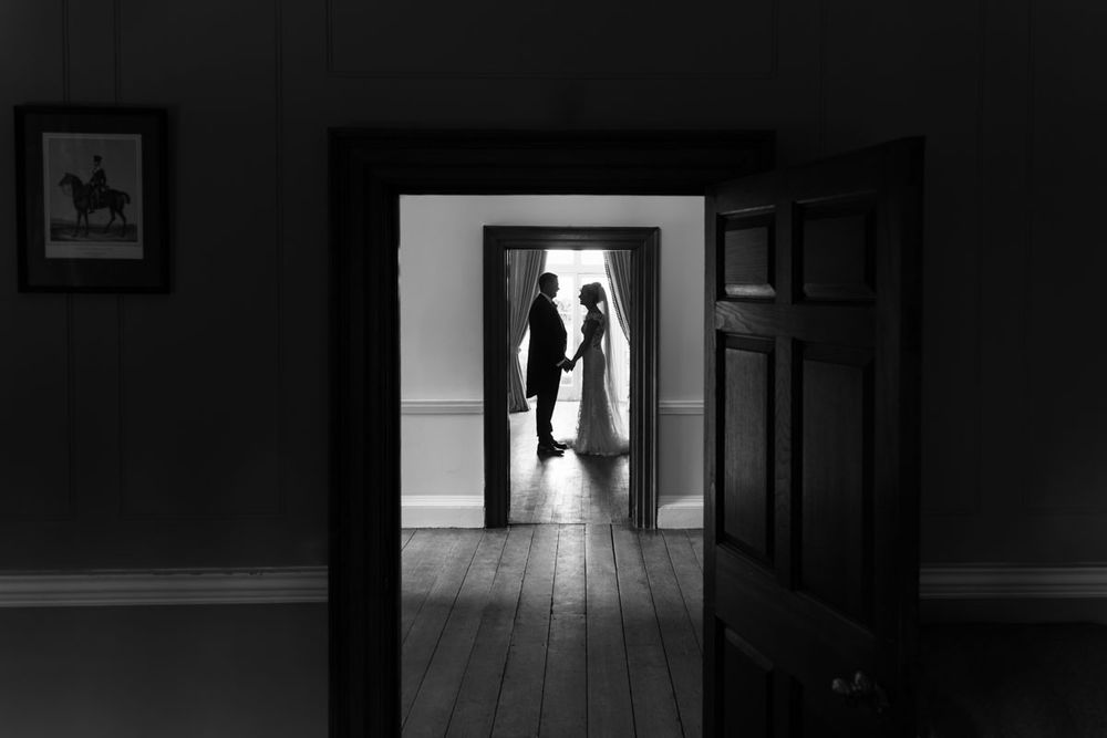 Bride and groom in country house framed by two doorways