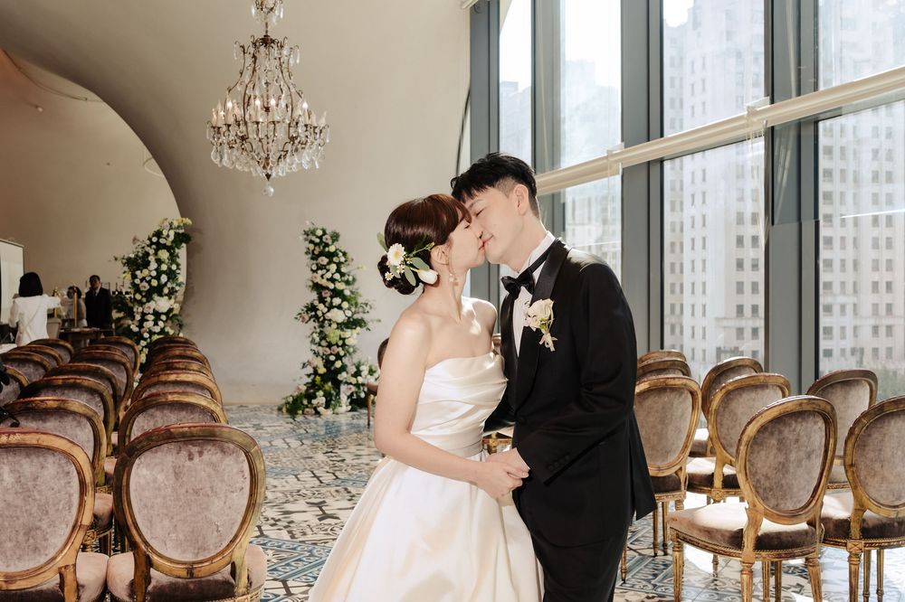 台灣室內證婚婚禮紀錄，古典美式風格場地結合歐式線條與自然光設計，呈現純白高級質感。婚禮採自由浪漫的buffet形式，賓客自在互動，新娘以素雅精緻造型登場，新郎為音樂家，整體氛圍溫柔細膩。渴望影像以紀實婚禮攝影方式捕捉真實情感與自然互動，呈現電影感敘事畫面，留下富有故事性的婚禮回憶