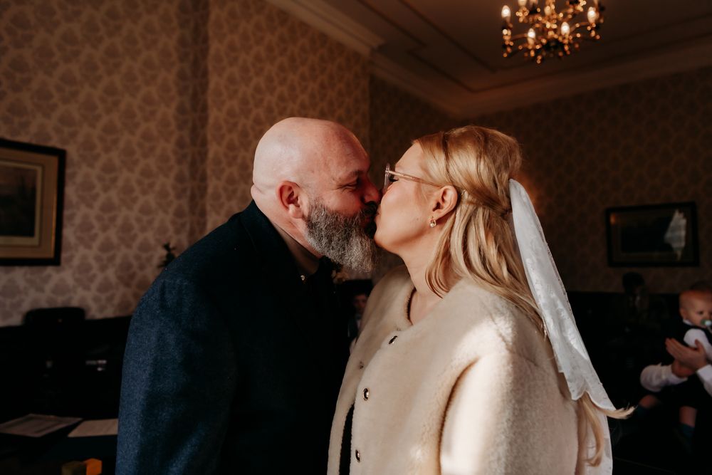 A couple dances together in an intimate moment at an indoor venue with elegant lighting and decor.