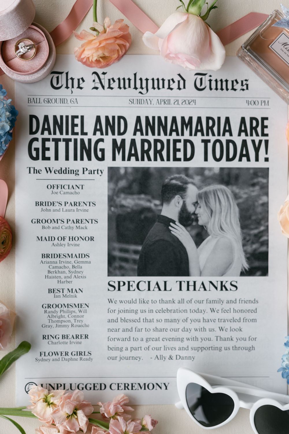 Custom wedding newspaper announcement styled with pink roses and engagement ring.