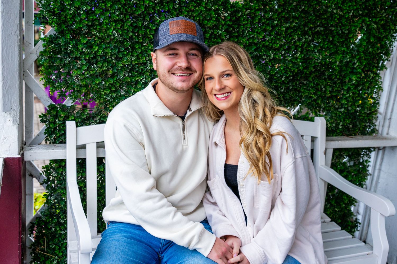 Young couple sitting in front of Martha's Market in Downtown Dandridge, TN for couples photography session by Jefferson County photographer