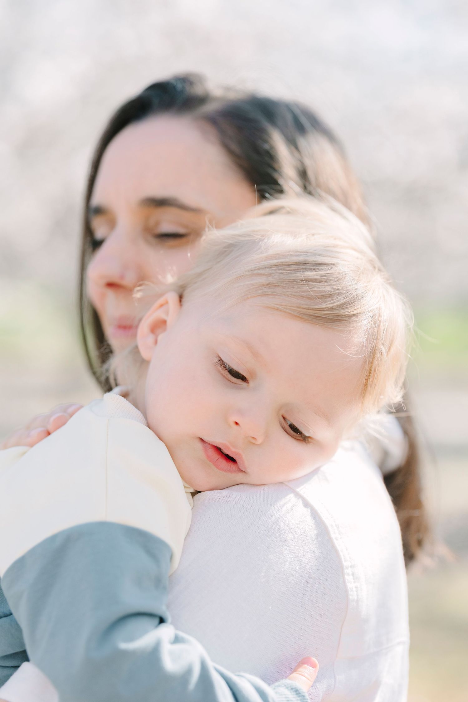 Tender embrace captured in soft, dreamy lighting during spring photoshoot.