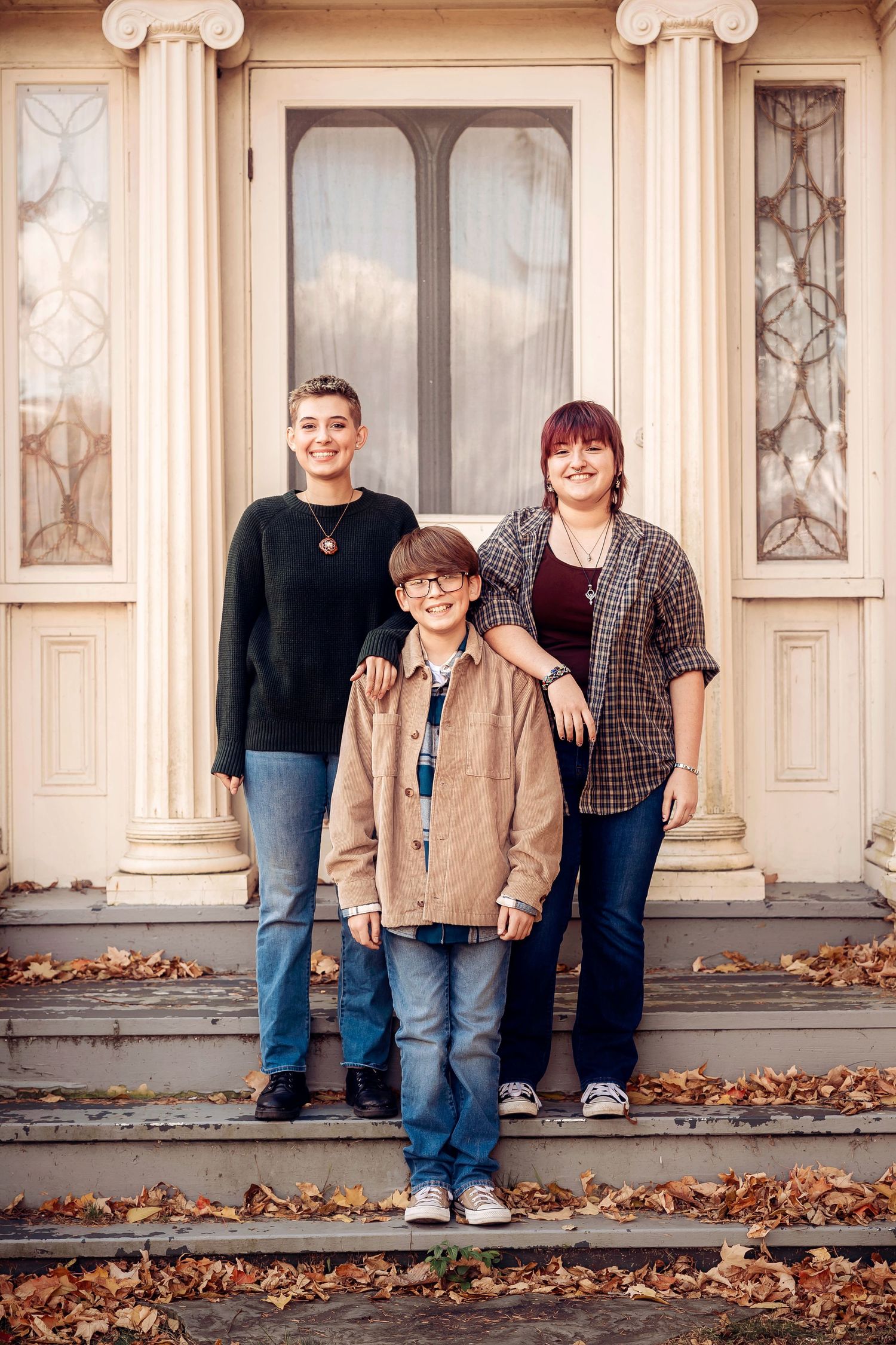 Three siblings pose on front steps of a historic building with ornate columns. Michigan Detroit Novi Northville Portrait Photographer