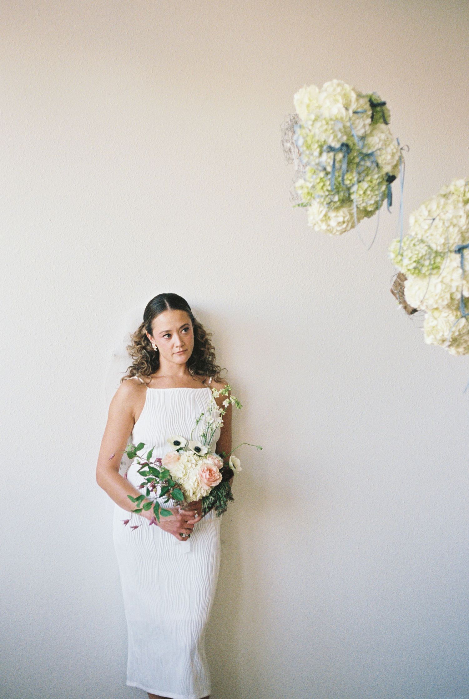 White hydrangea arrangements float above a simple white backdrop.