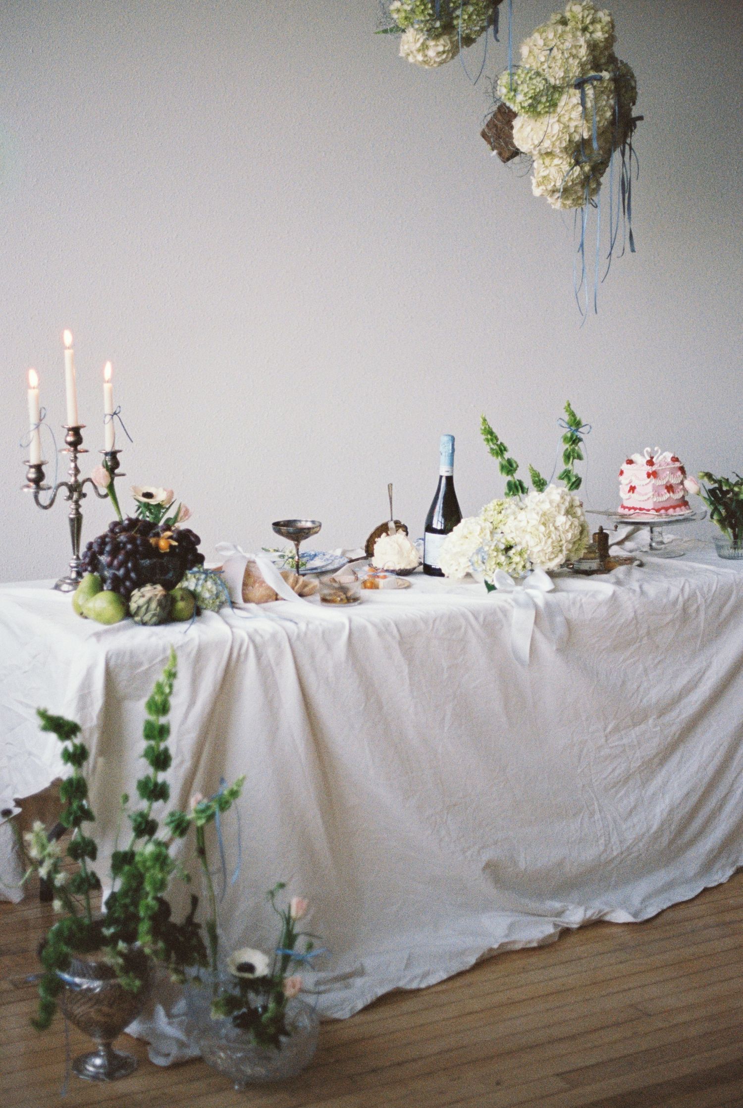 Elegant wedding reception table with candelabras, flowers, and white linens.