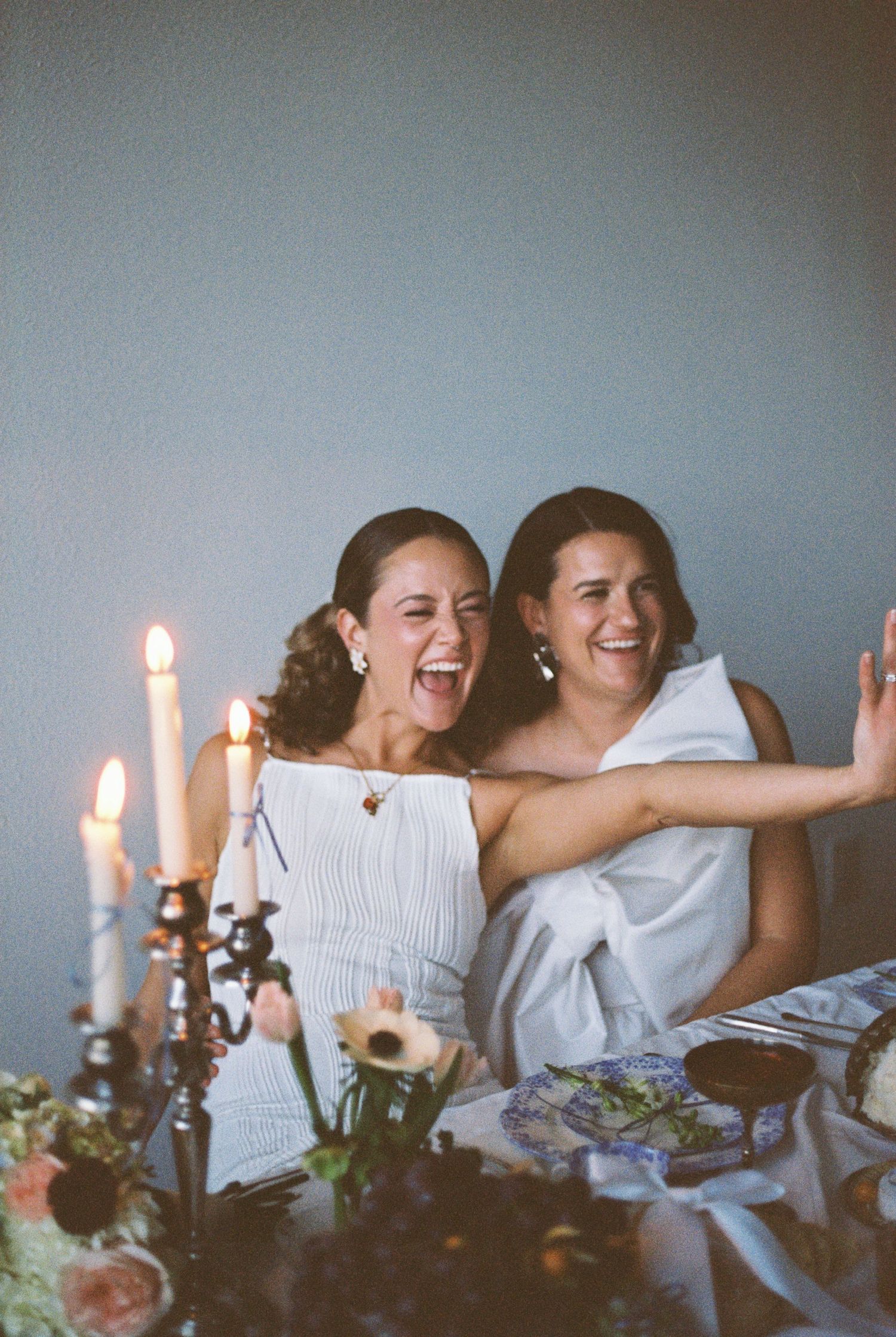 Candlelit celebration with laughter and joy at an intimate wedding table.