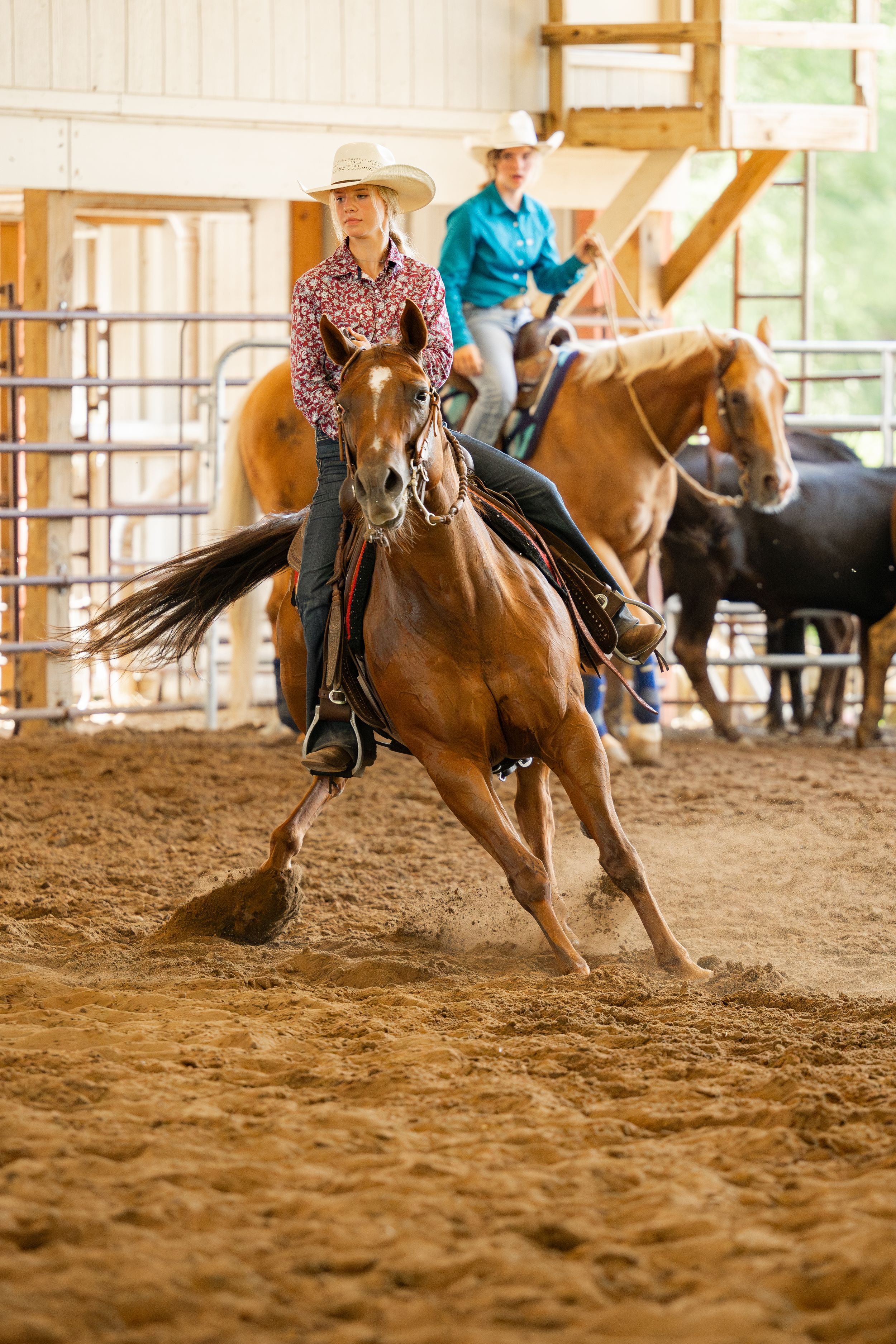 Horse and rider performing western riding maneuvers in indoor arena during practice.