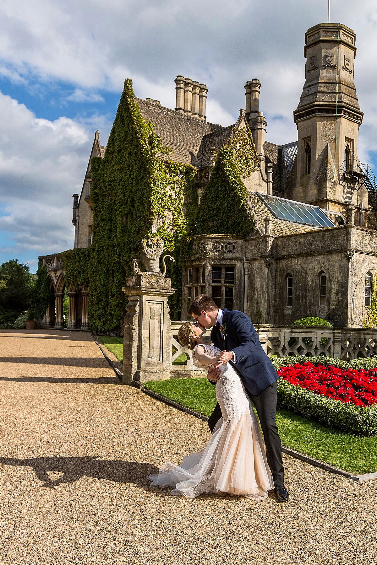 bride and groom kissing, standing in front of the manor by the lake hotel