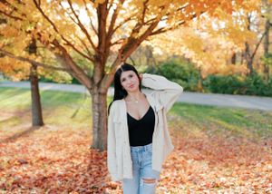 Casual fall fashion photographed under golden maple trees with fallen leaves.