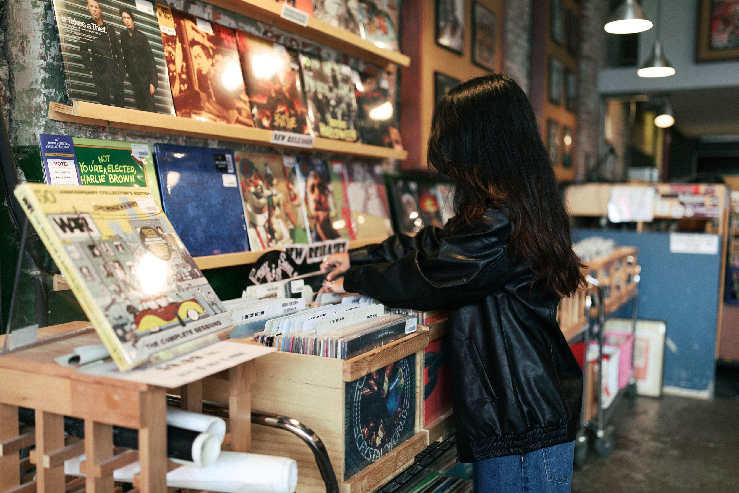 Person browsing vinyl records at music store.