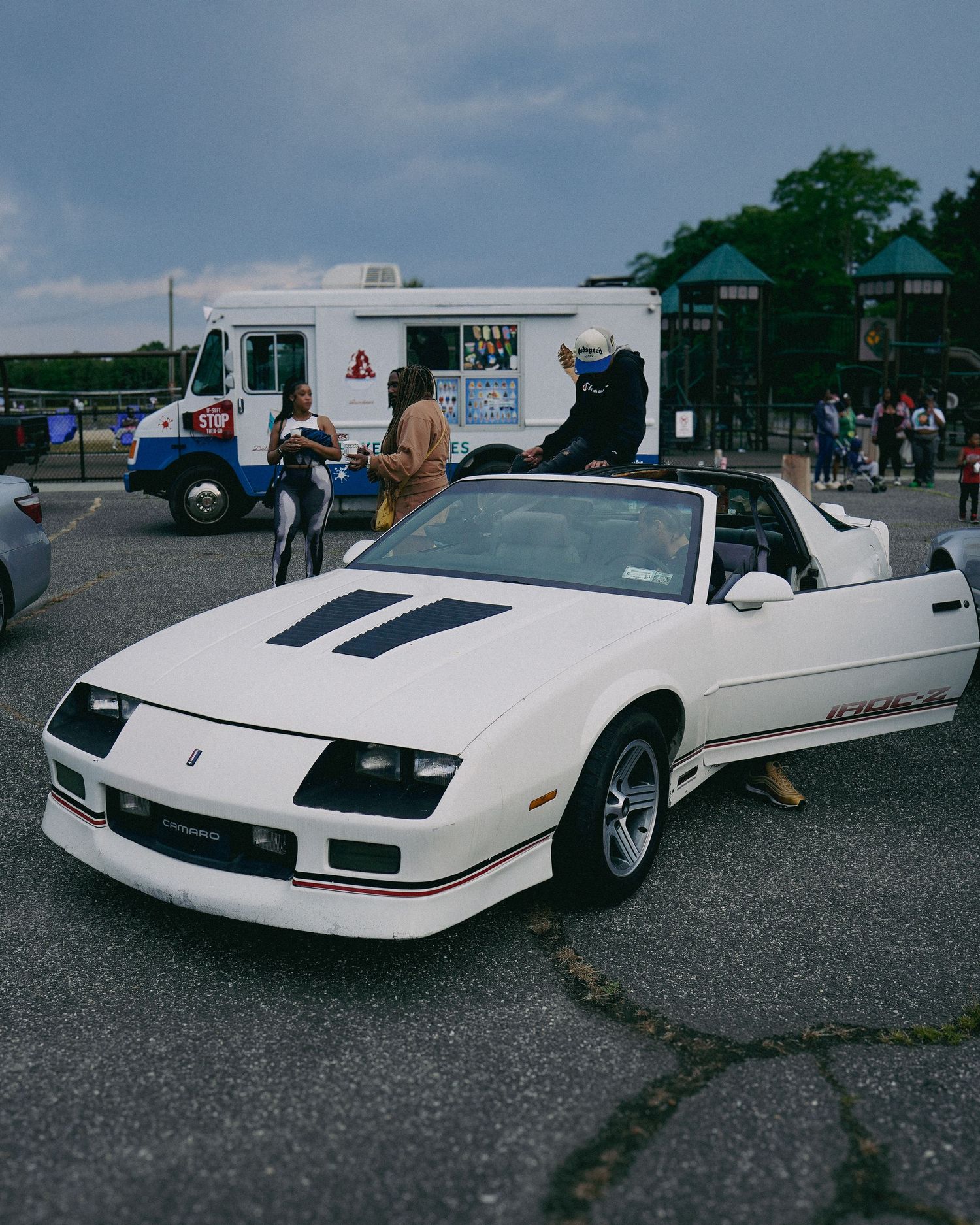 Classic white Chevrolet Camaro convertible parked at outdoor event.