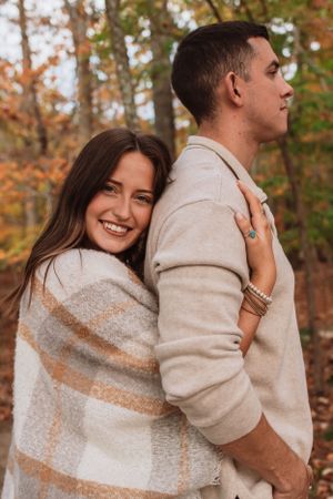 Couple in front of fall trees for family session captured by Maryland family photographer Mallory Bramlett.