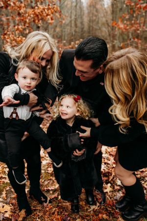 Family standing between fall trees captured by Maryland family photographer Mallory Bramlett,