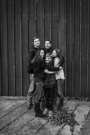 Family giving each other big hug for outdoor family photography session captured by Maryland family photographer Mallory Bramlett.