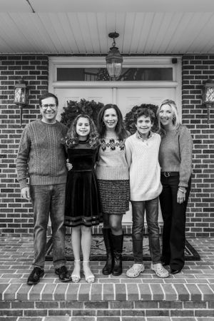 Family on front porch for in home family photoshoot captured by Maryland family photographer Mallory Bramlett.