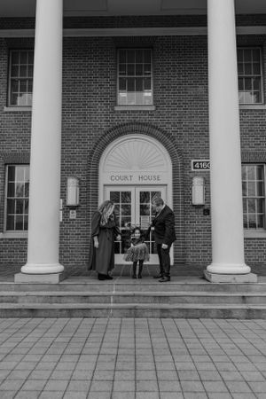 Family in front of courthouse for adoption ceremony photography session captured by Maryland family photographer Mallory Bramlett.