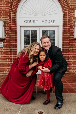 Family in front of courthouse for adoption ceremony photography session captured by Maryland family photographer Mallory Bramlett.