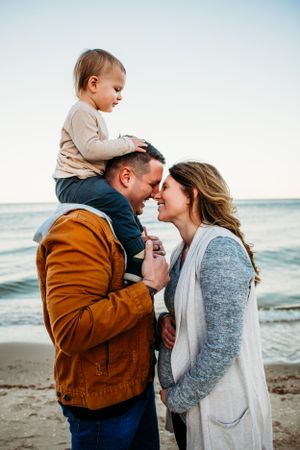 Family on beach for family maternity portraits captured by Maryland family photographer Mallory Bramlett.