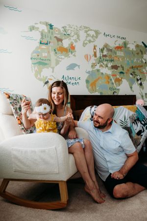 Mother and father in nursery with infant for in home family photoshoot captured by Maryland family photographer Mallory Bramlett.