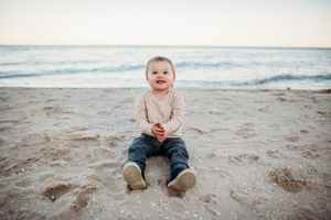 Toddler sitting on beach for family photography session captured by Maryland family photographer Mallory Bramlett.
