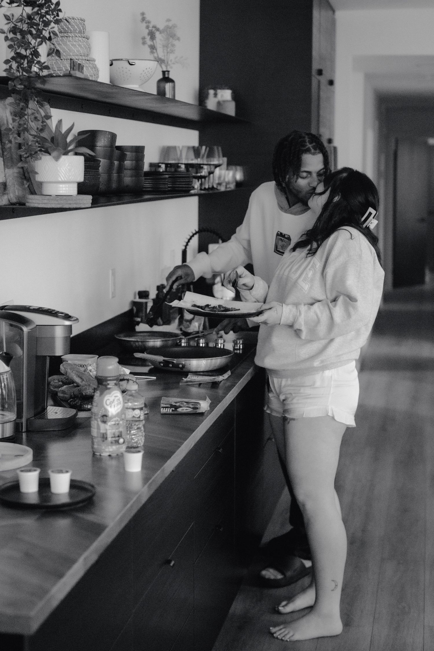 A cozy kitchen scene with two people preparing food together at the counter.