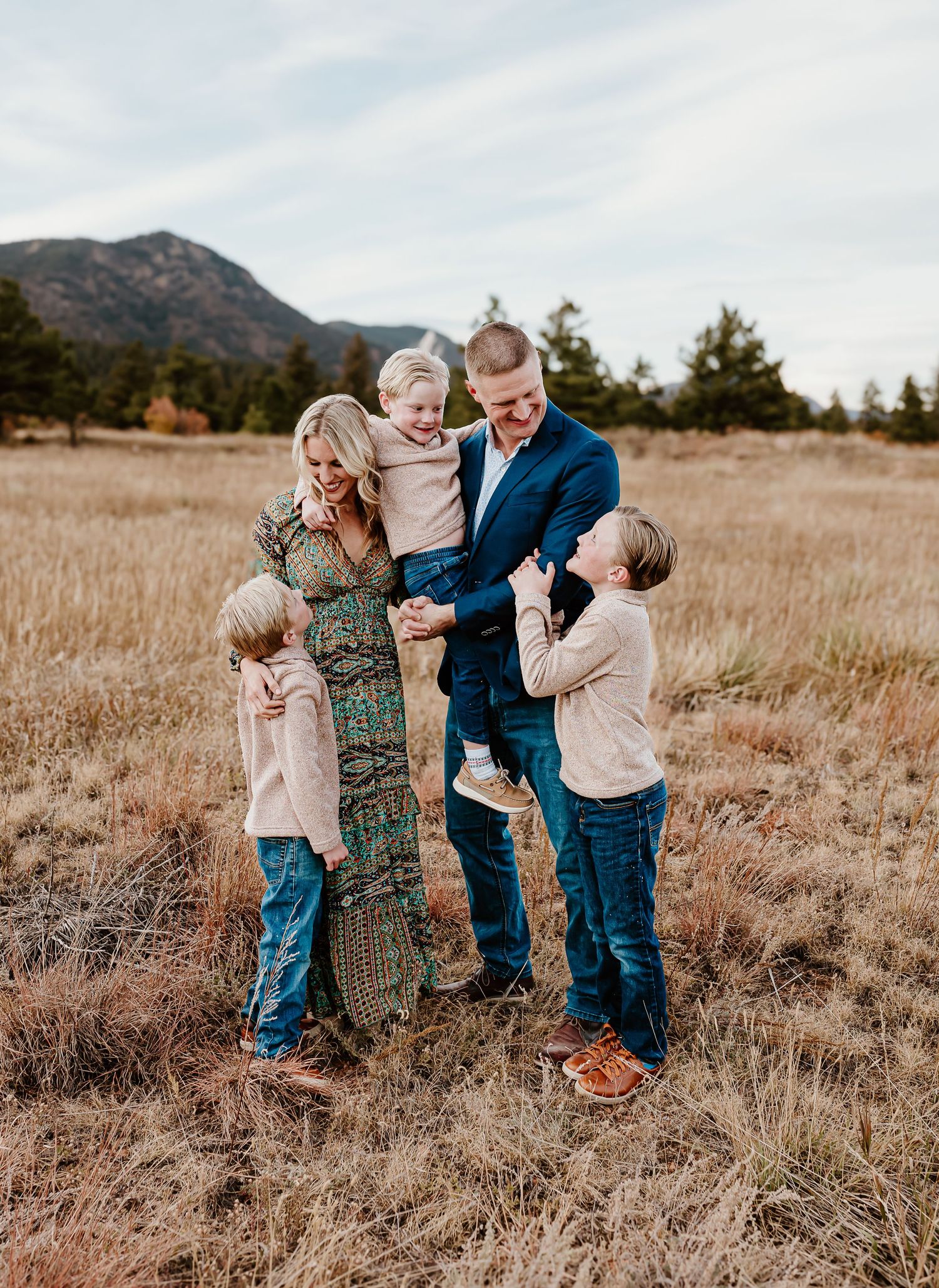 Close-up of two hands touching tenderly at sunset with an engagement ring visible.Colorado Springs Photographer
