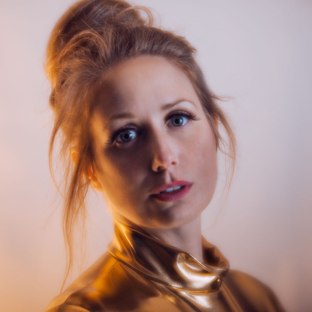Soft focus portrait with warm lighting and golden tones.