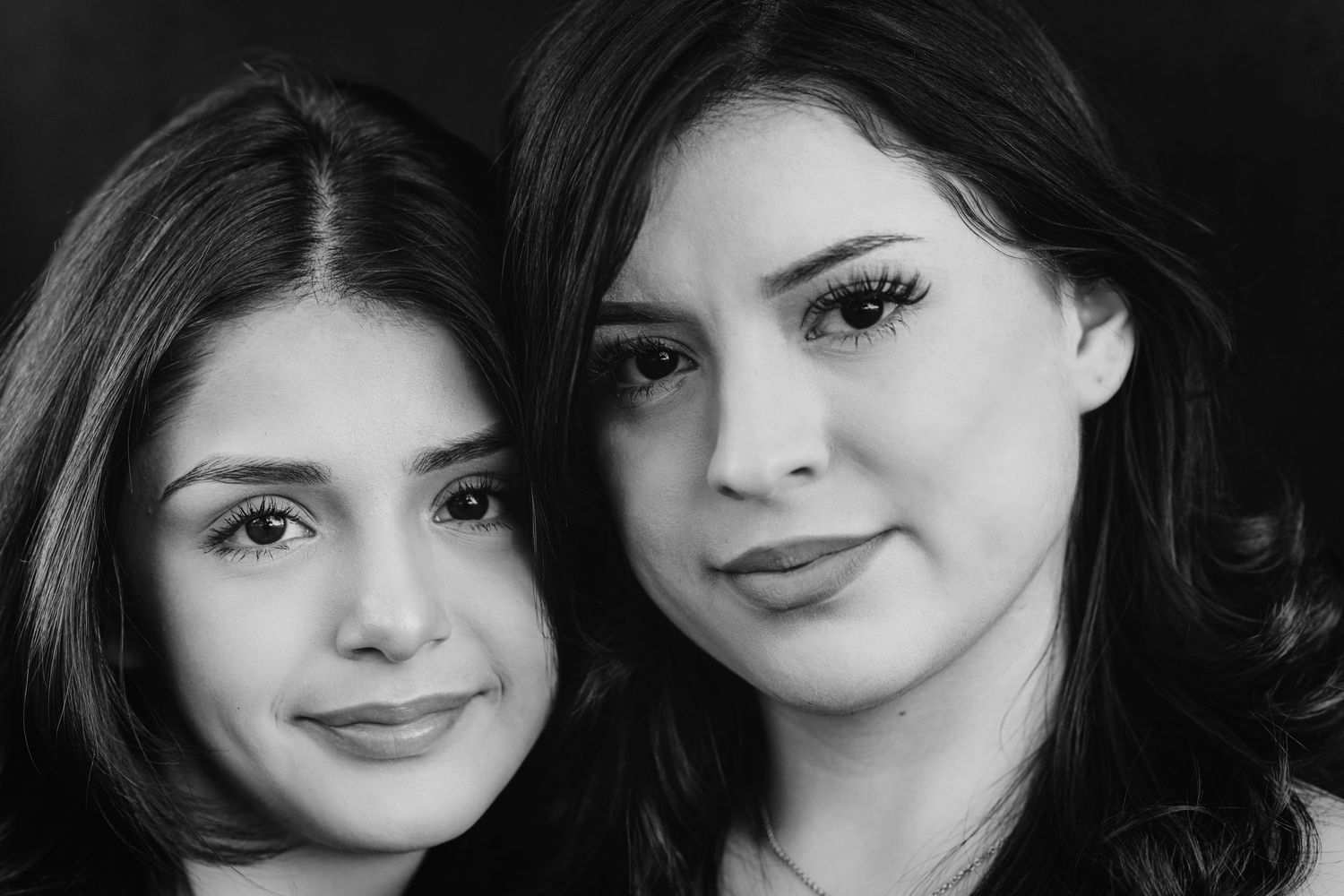 Black and white close-up portrait of two people with dark hair.
