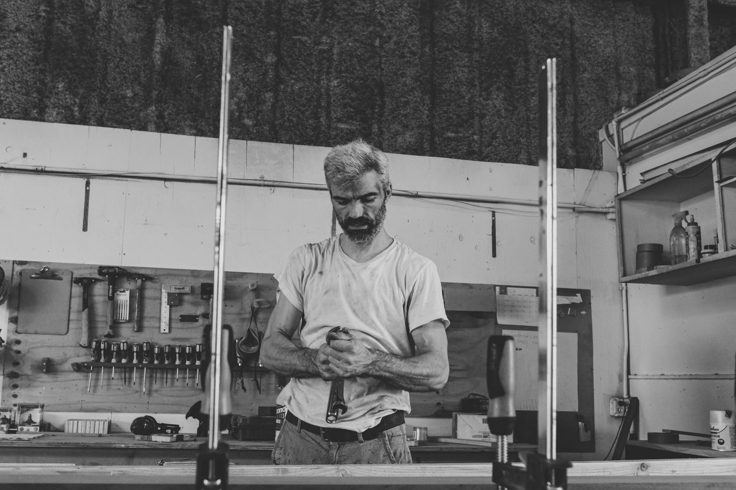 Black and white image of person working behind counter in commercial kitchen setting.