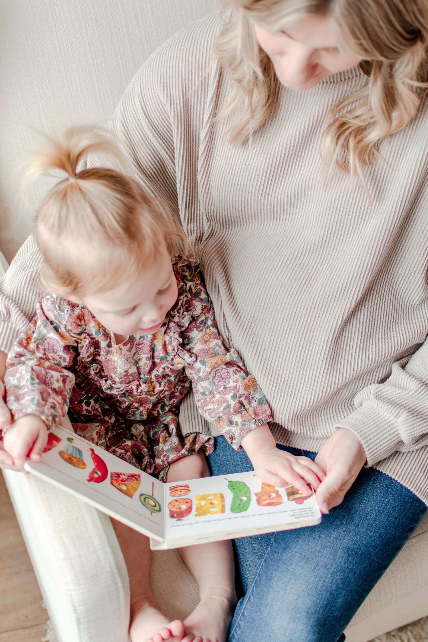 Mom reading with toddler during an in-home family photo session.