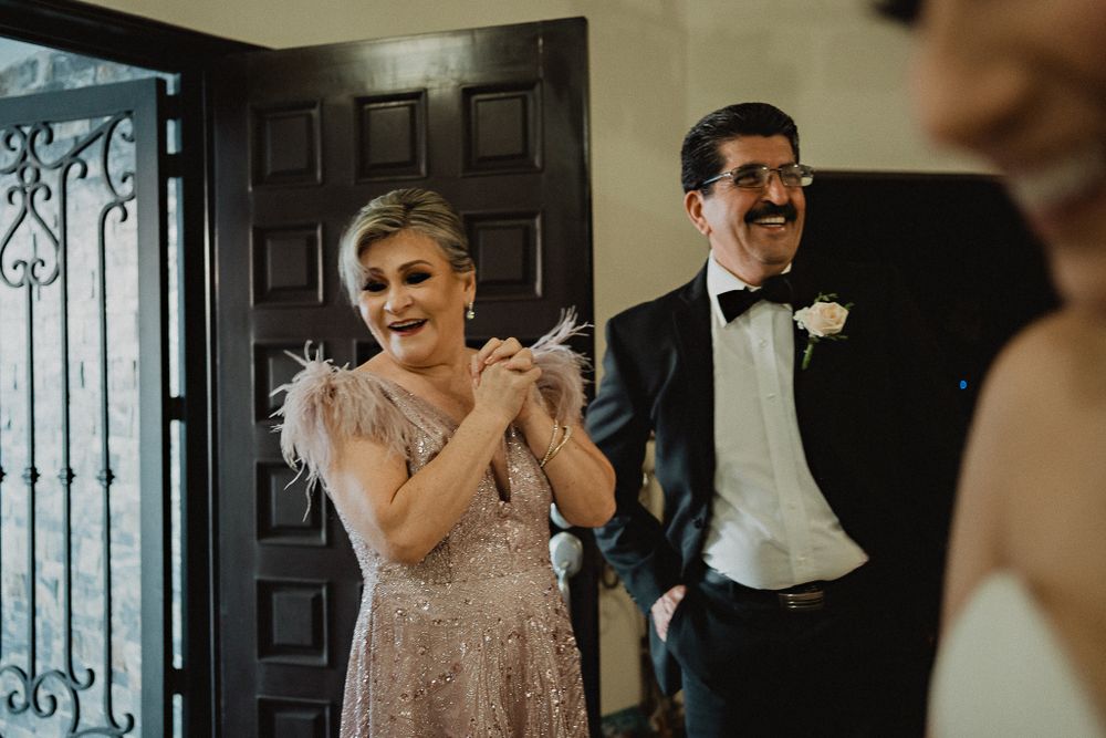 Parents beaming with pride as they see their daughter dressed as a bride, an emotional moment