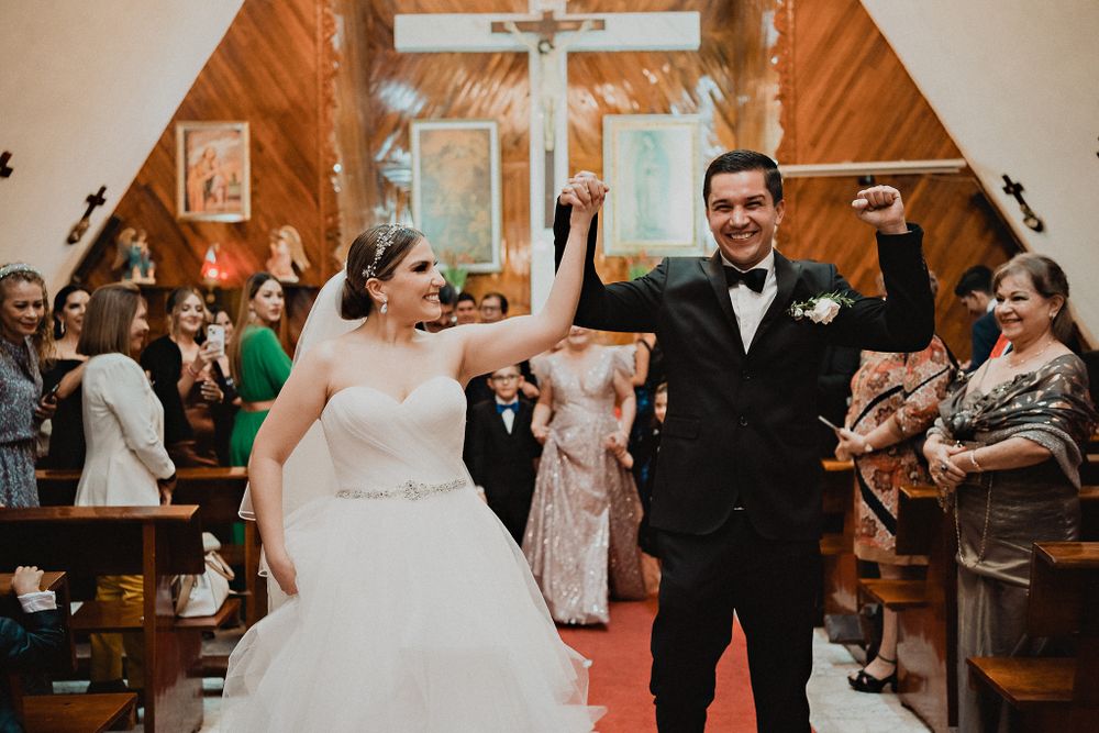 Couple making their grand exit from the church, celebrating their love surrounded by applause