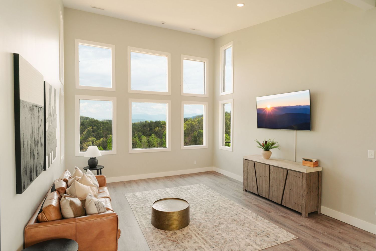 Modern living room with large windows, plush seating, and scenic mountain views.