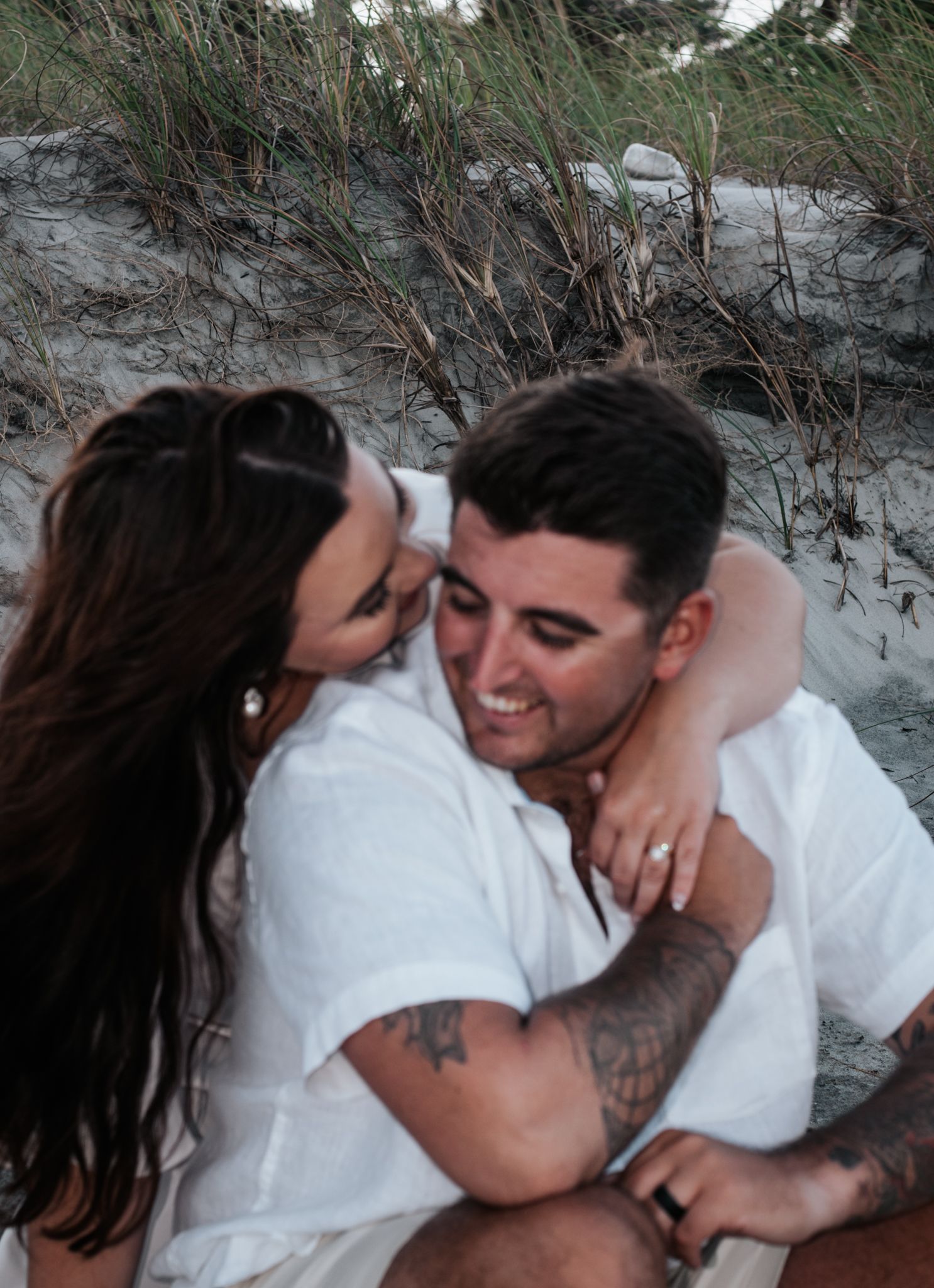 An intimate close-up of a couple sharing a tender moment on the beach.