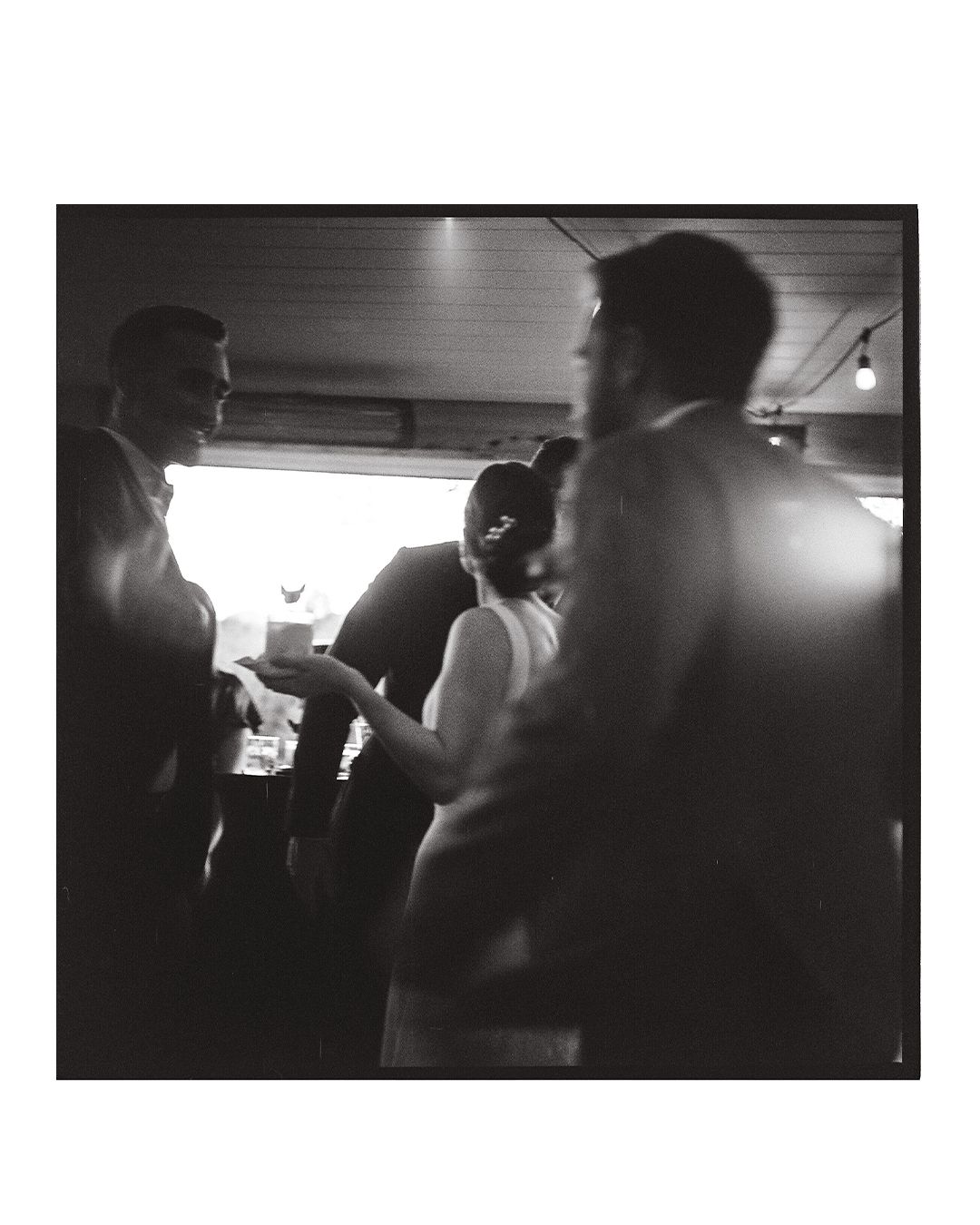 Dark atmospheric shots of wedding guests dancing at an evening reception.