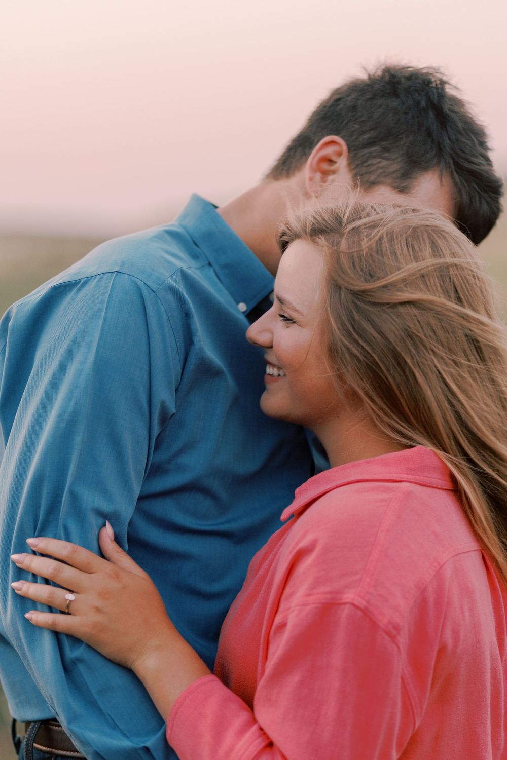 Romantic couple embracing outdoors at sunset.