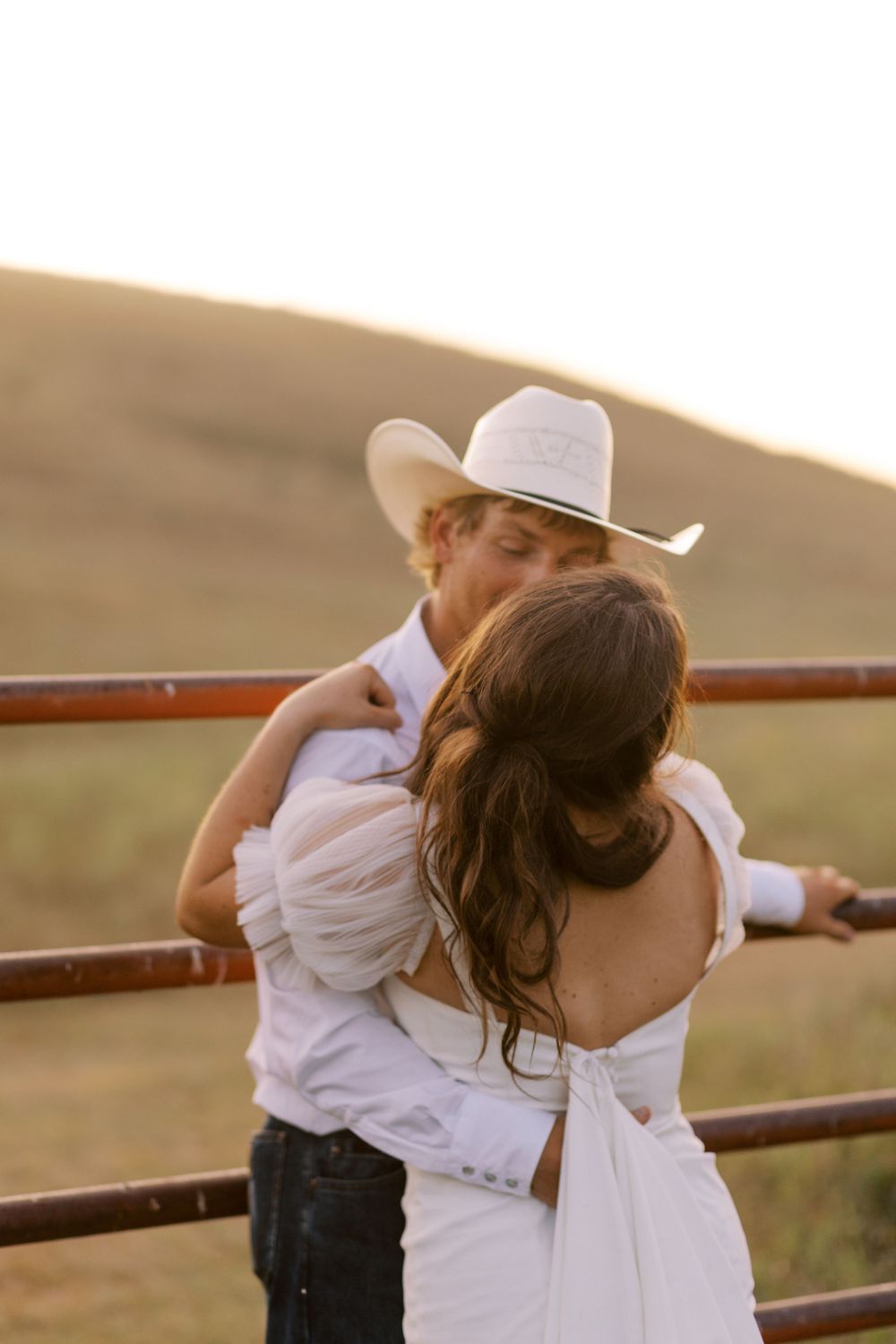 Romantic sunset moment by rustic fence in countryside setting.