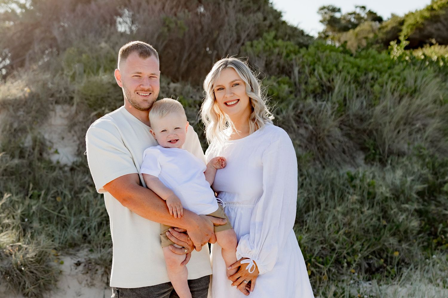 Happy family sharing tender moment during beach photoshoot.