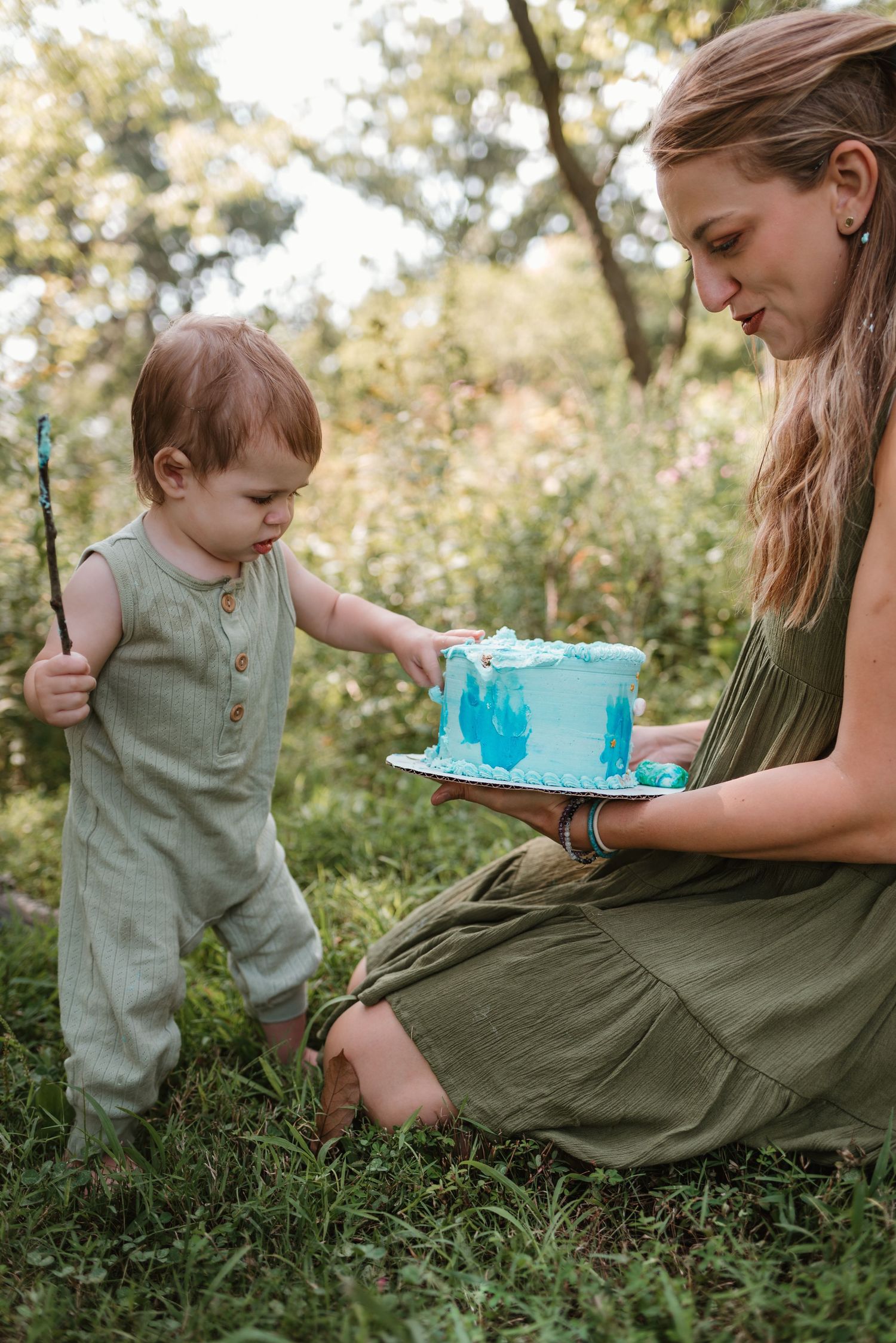 Sweet moment of sharing blue birthday cake in outdoor garden setting.