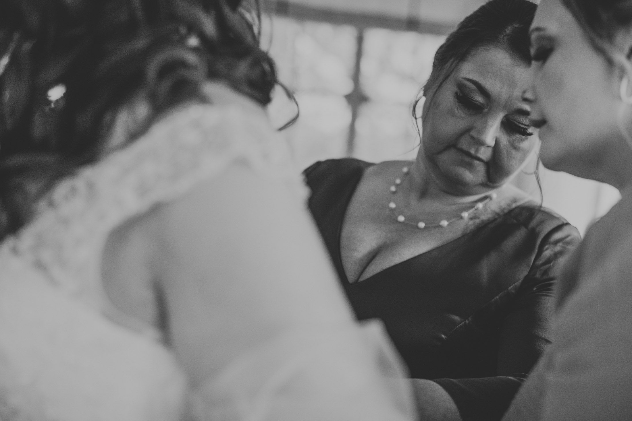 Intimate candid moments captured during wedding preparation in soft natural light.