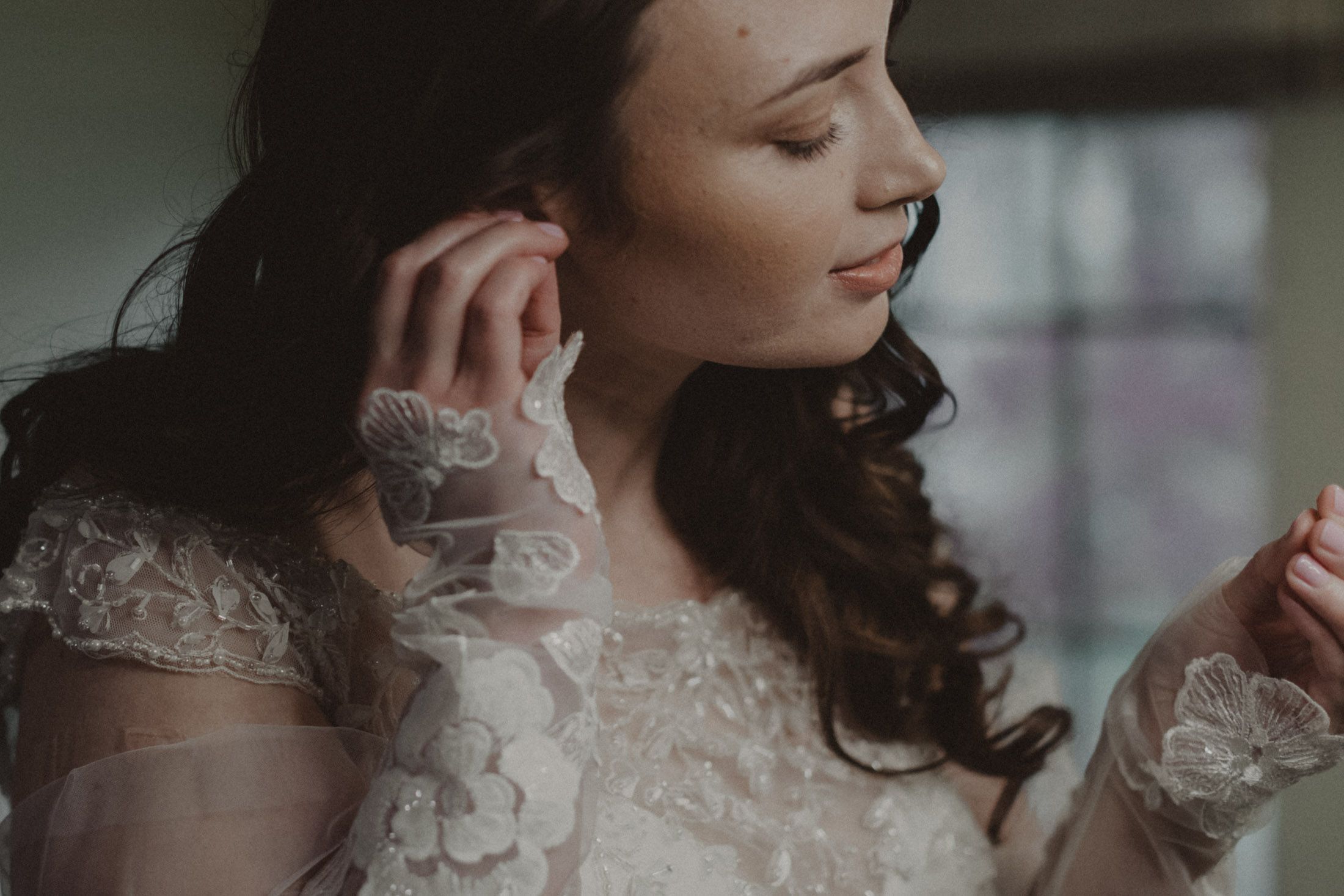 Artistic close-up portrait shot in soft natural window light with delicate lace details.