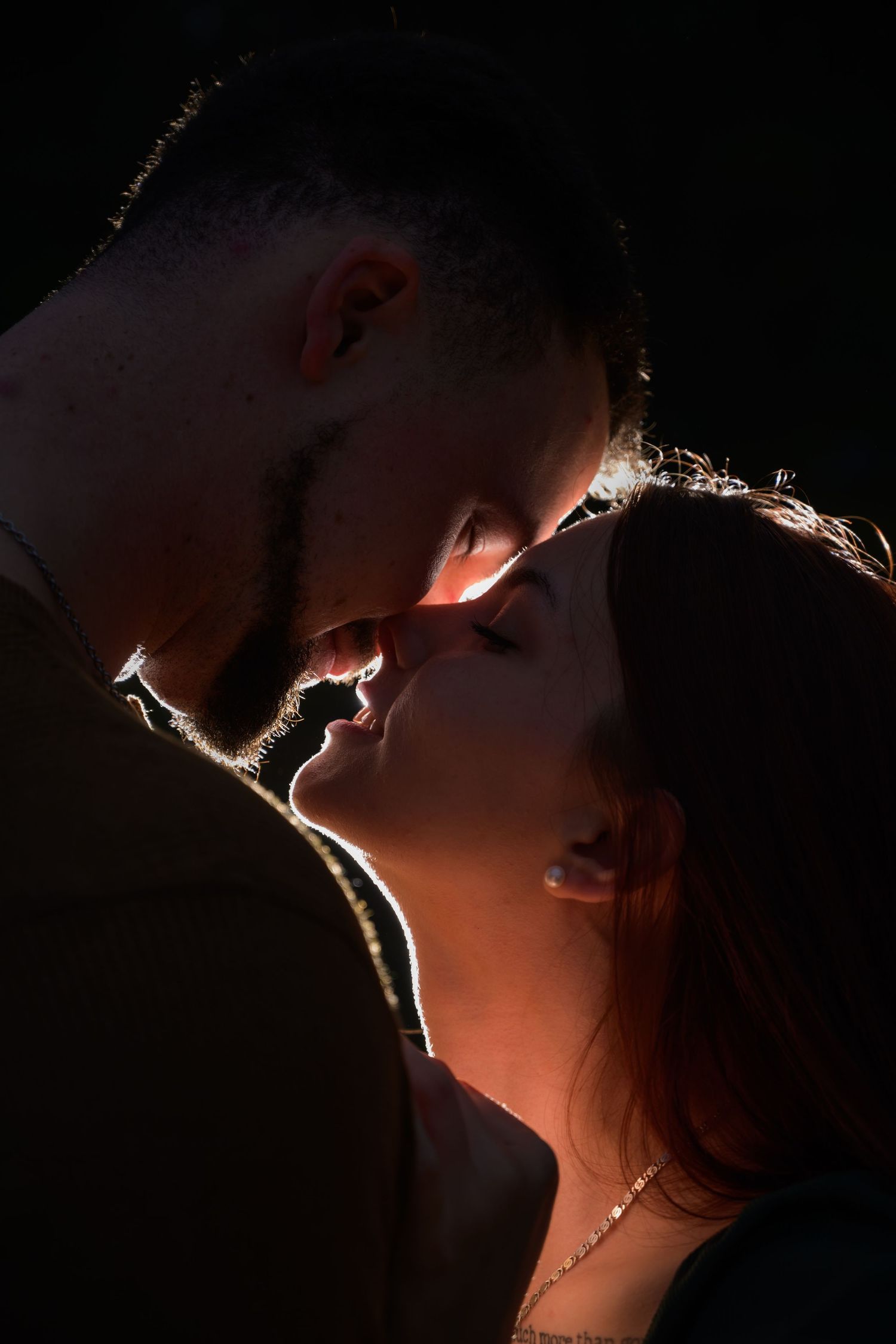 Silhouetted profile of a person's face against dramatic backlighting creating a moody artistic portrait.