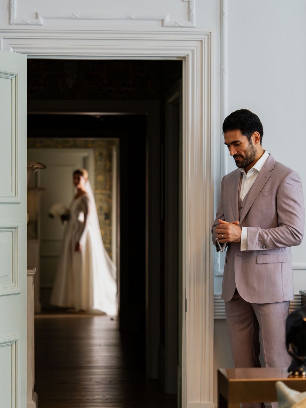 Elegant hotel interior with hardwood floors and white doorways in natural light.