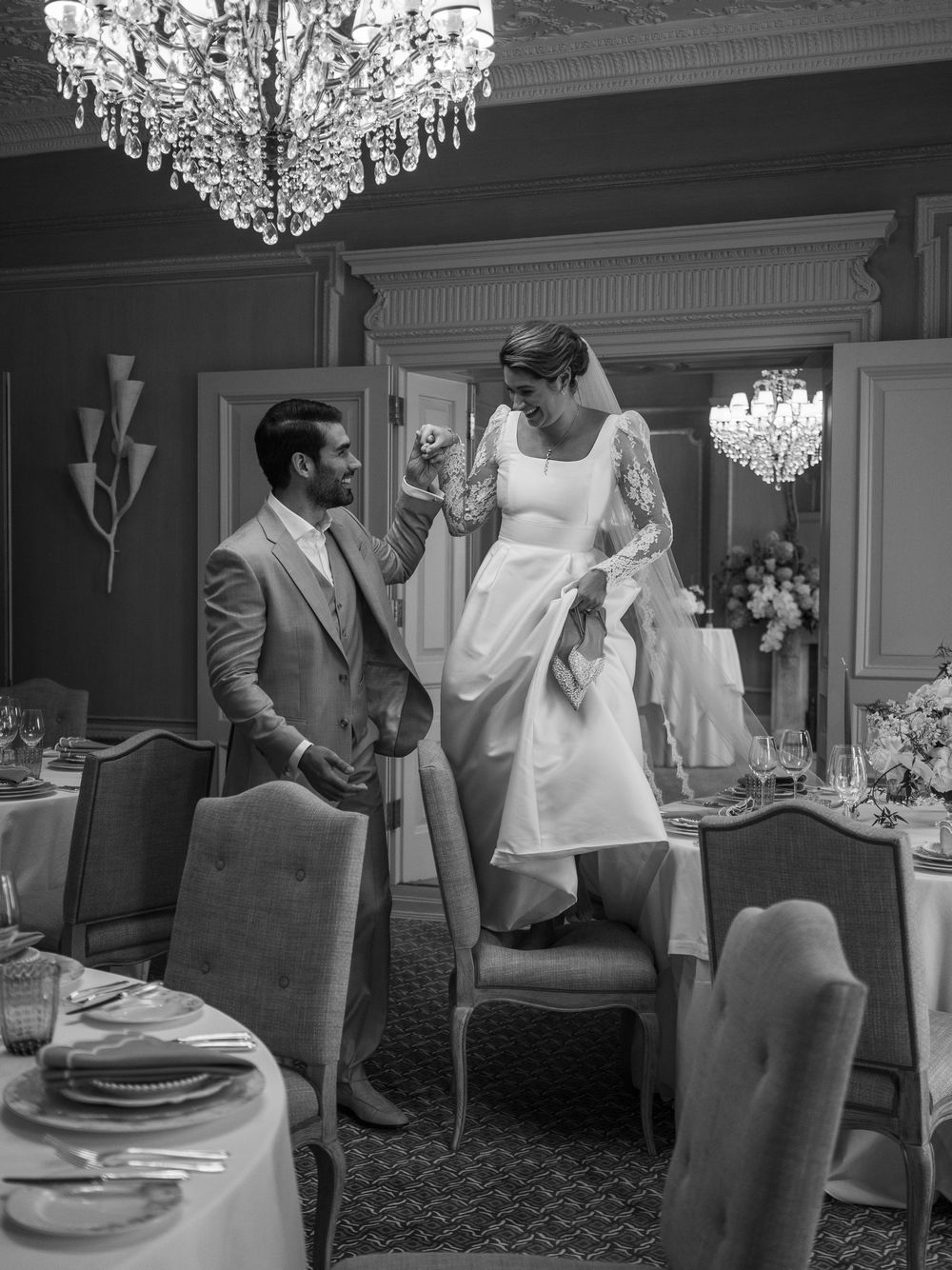 Elegant dining room with crystal chandeliers showcases a series of interactions during a wedding reception.