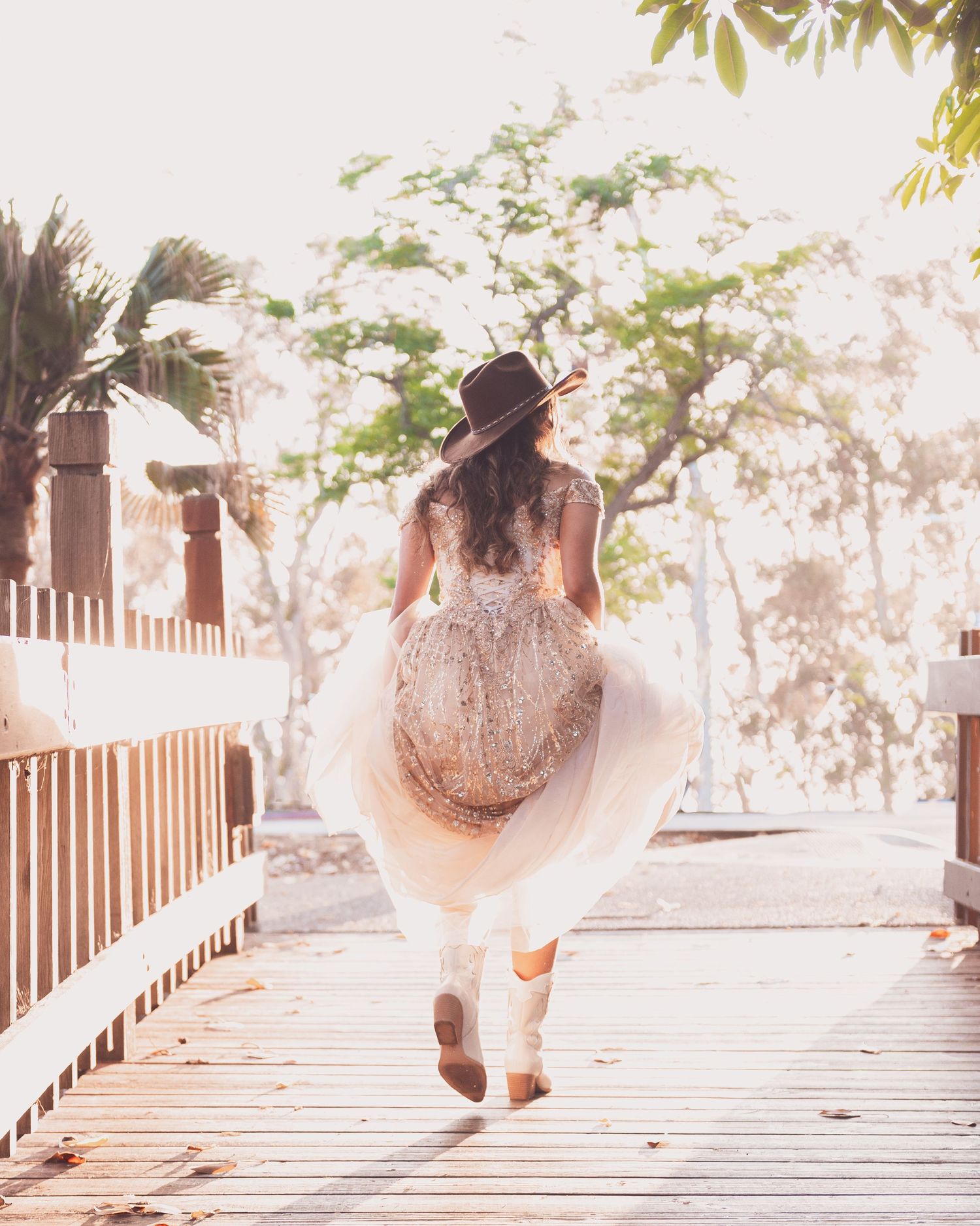 A sequence of dreamy photos showing a flowing ballgown on a wooden boardwalk in soft sunlight.