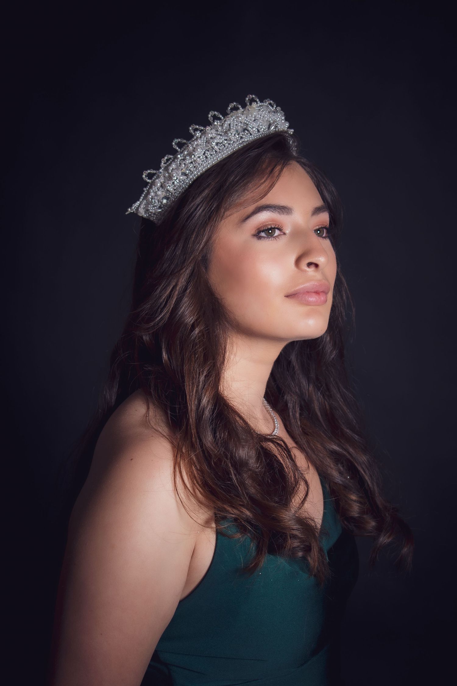 A dramatic portrait series of a woman in a dark green dress against a black background with moody lighting.