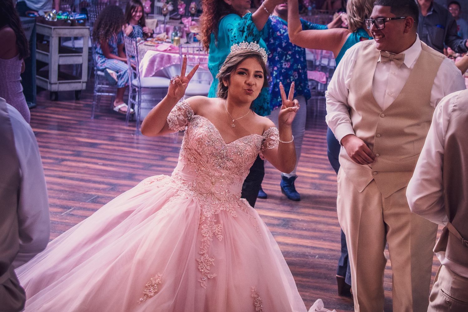 A couple performs their first dance at a wedding reception in a beautifully lit ballroom.