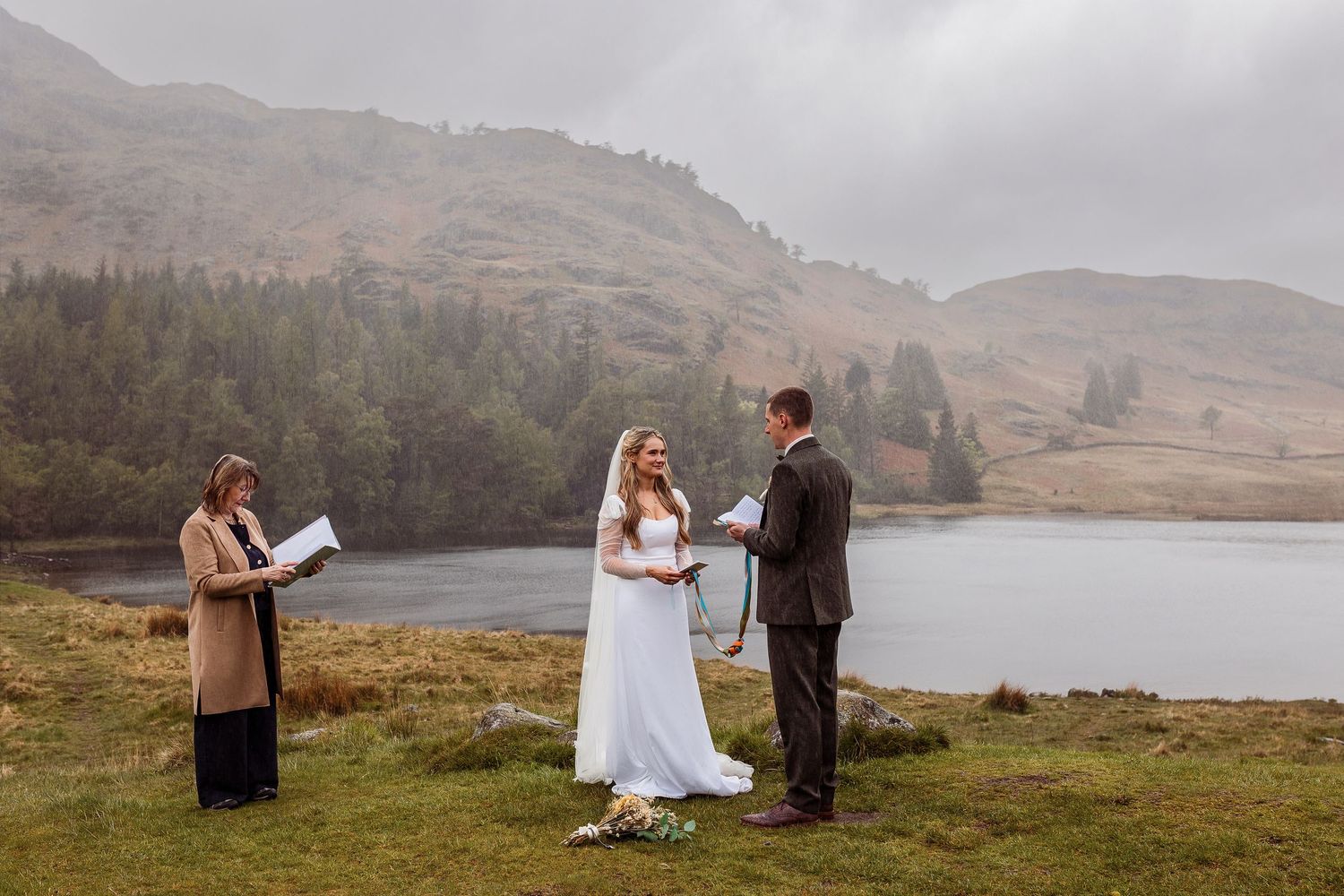 Annie and Luke run hand in hand through the beautiful summer gardens at their wedding at the Cragwood Hotel in Windermere.